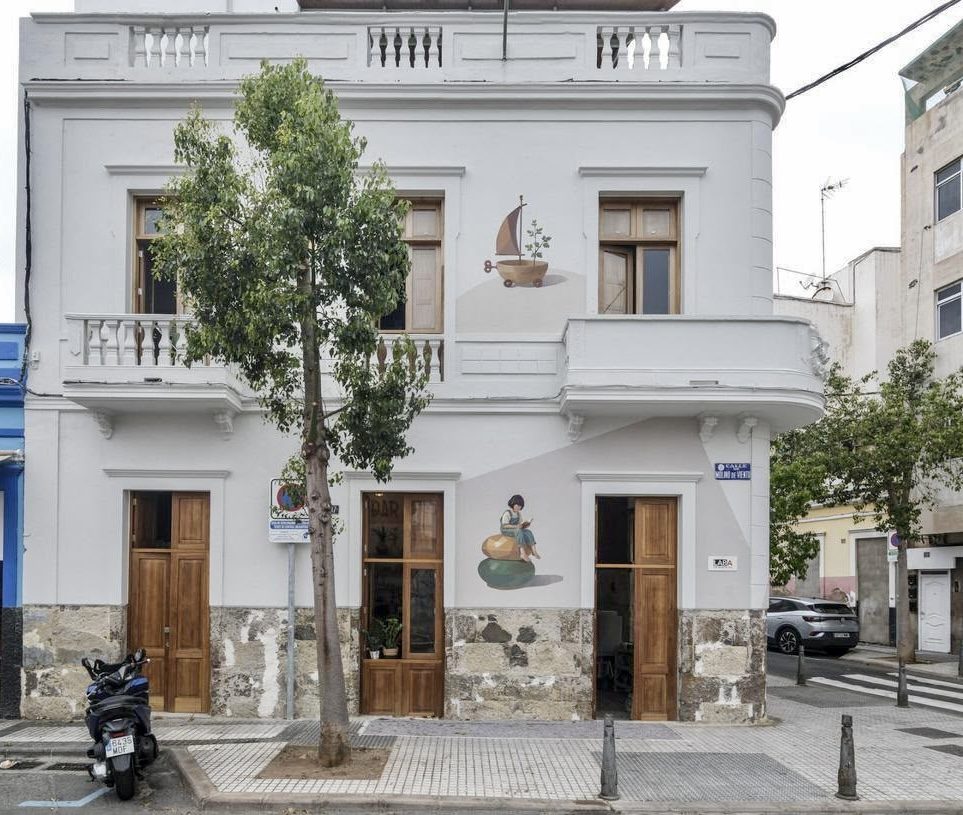Fachada de Casa M con el mural cerámico y su entorno urbano