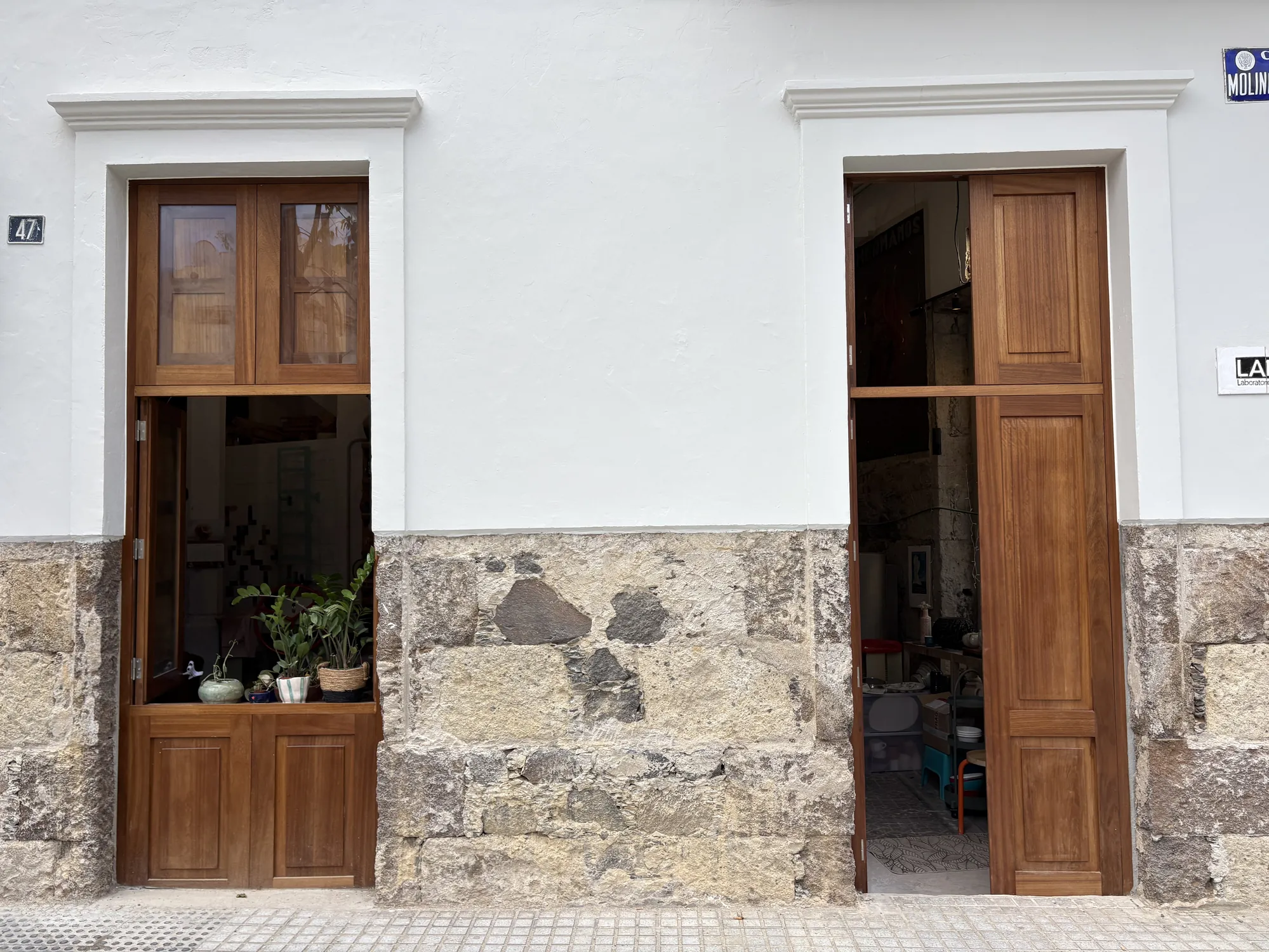 Entrada de LABA en Casa M: mampostería de piedra, carpintería de madera y plantas