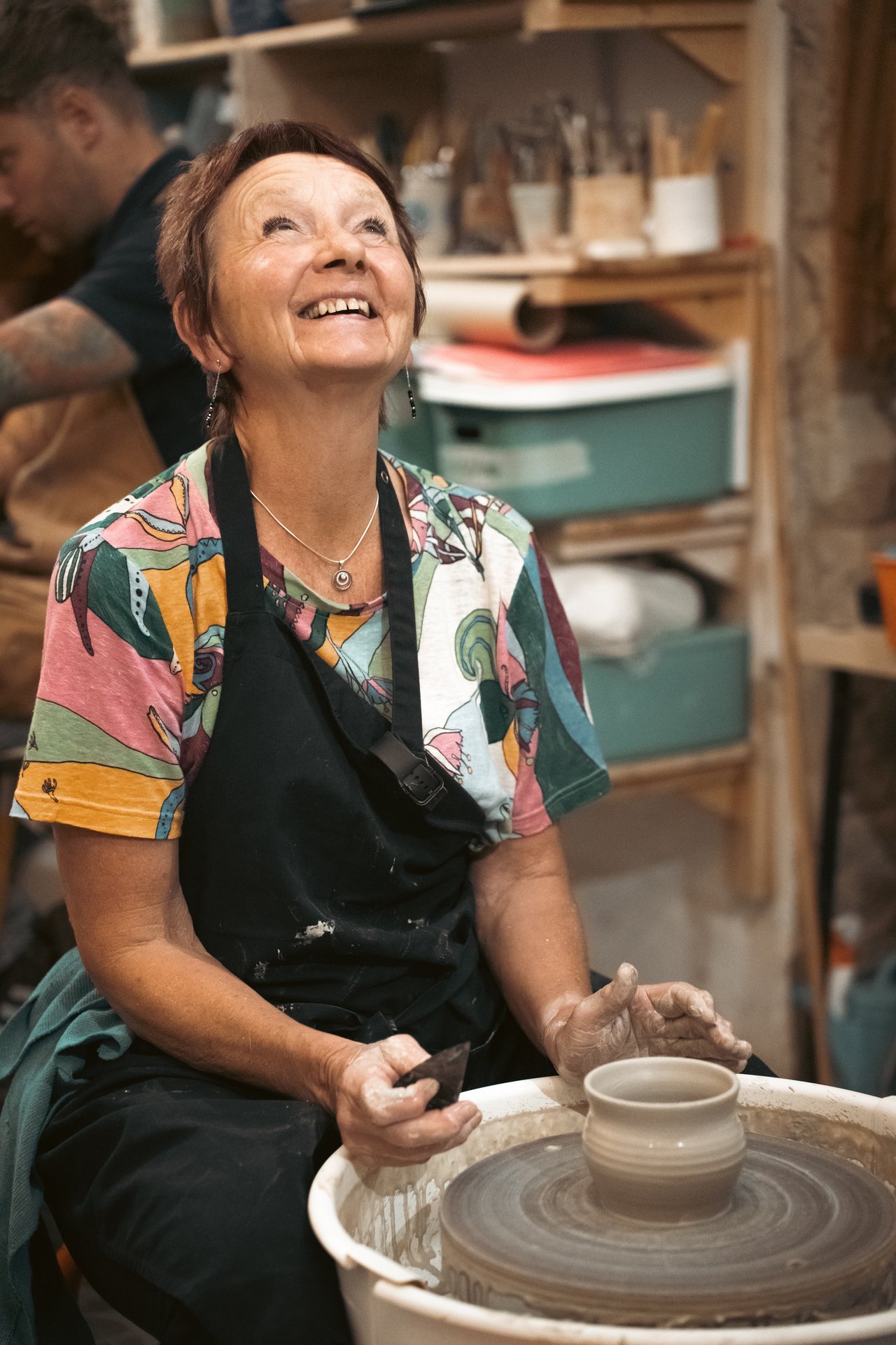 Alumna sonriendo mientras trabaja en el torno